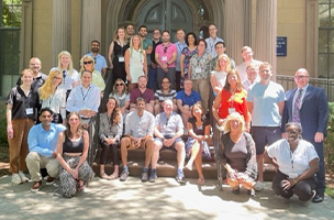 A group photo of cohort 2 sitting outside a stone building