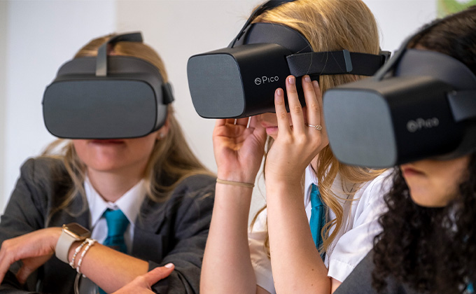 3 students wearing Virtual Reality headsets.