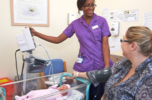 Picture of a midwife with a parent and their baby